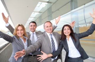 Group of happy business people with arms up